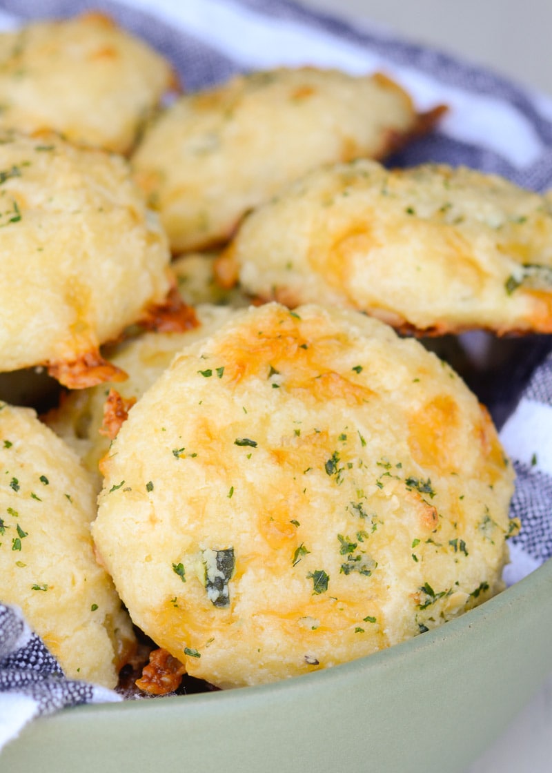 Closeup shot showing a bowl full of cheesy keto biscuits with cheddar, cream cheese, and mozzarella