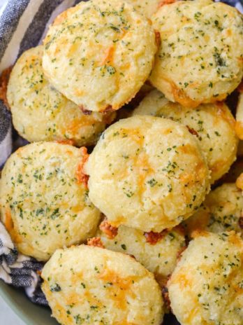 These Keto Three Cheese Biscuits are perfectly soft and fluffy! Each low carb biscuit is loaded with sharp cheddar cheddar, mozzarella and fresh basil for just 2 net carbs each!  