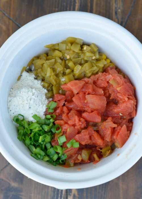 canned tomatoes, green chilis, powdered ranch seasoning, and chopped green onions in a slow cooker