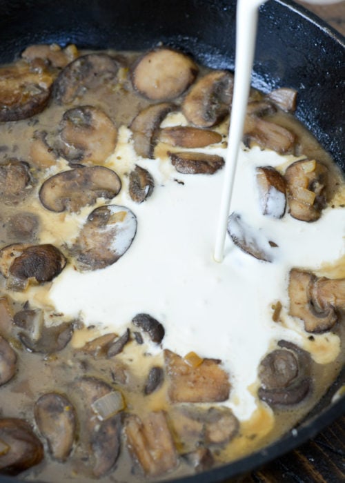 heavy cream being poured into a pan sauce with mushrooms, garlic, and shallots