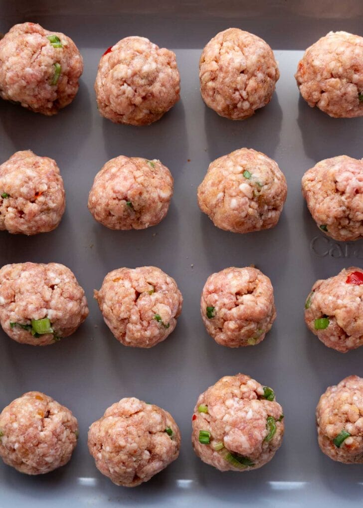 uncooked meatballs on a pan