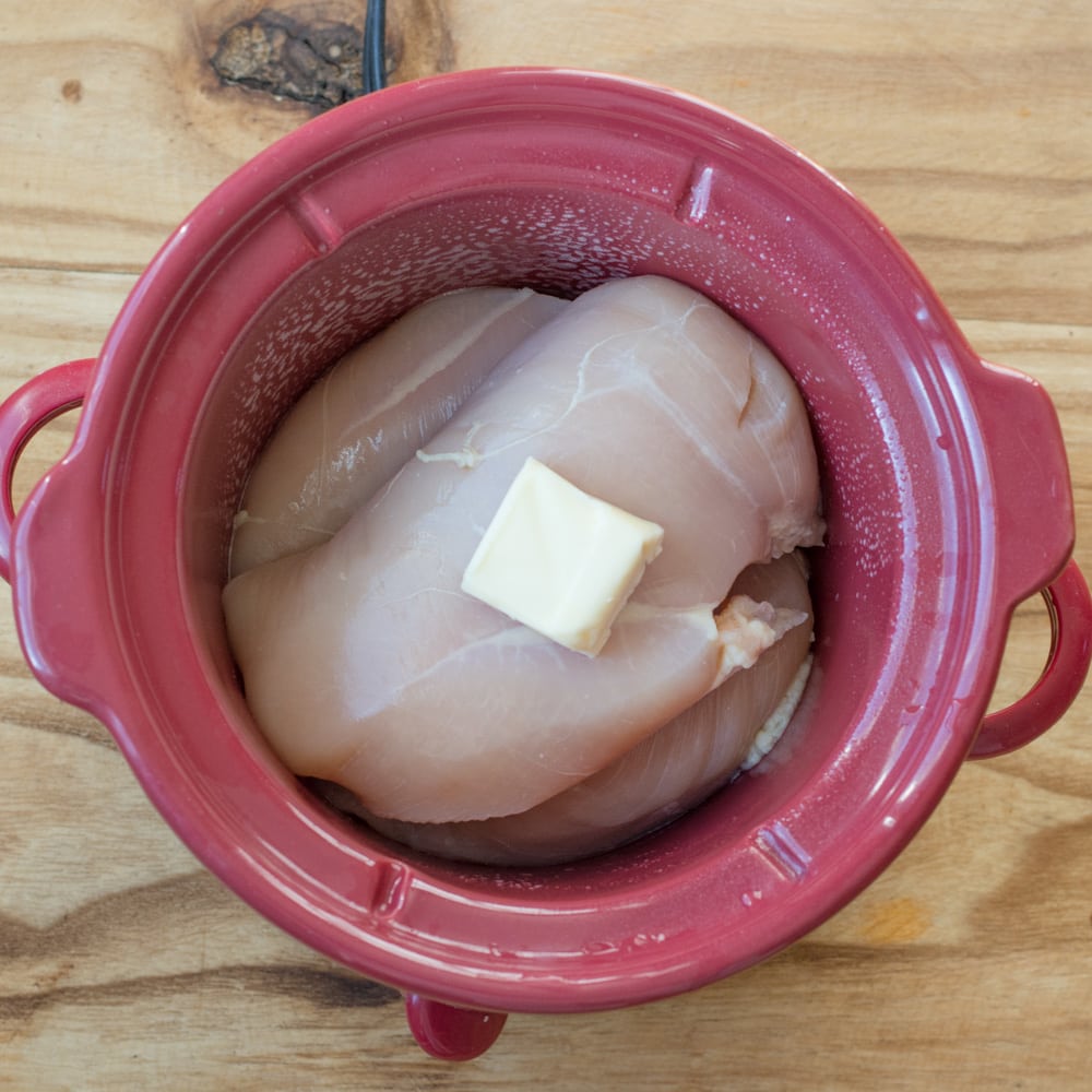 boneless skinless chicken breasts in a small slow cooker with butter