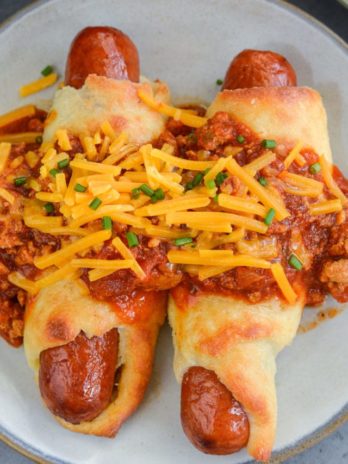 These Keto Chili Cheese Dogs have everything you love about this classic, without the carbs! Easy, low carb, gluten free pigs in a blanket are smothered with keto chili and shredded cheddar cheese! For about 5 net carbs per serving this is a low carb recipe you will love! 