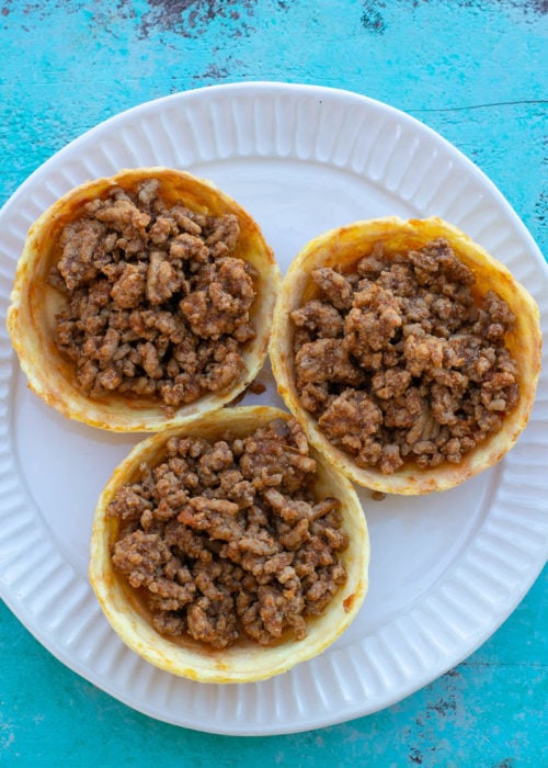 This Taco Chaffle Bowl is the perfect keto version of your favorite taco salad! Seasoned taco meat, cheese, lettuce and sour cream are combined in a crispy Chaffle Bowl for less than 3 net carbs!