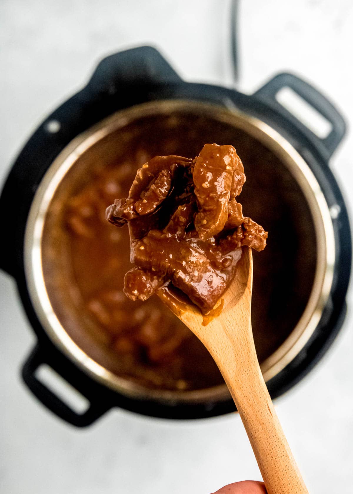 mongolian beef in instant pot close up with wooden spoon