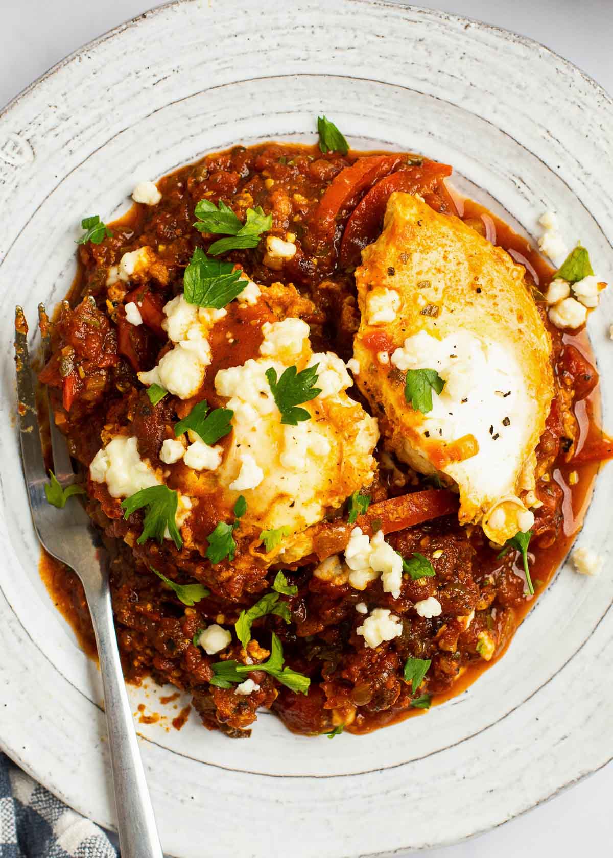 two poached eggs on plate with tomato sauce