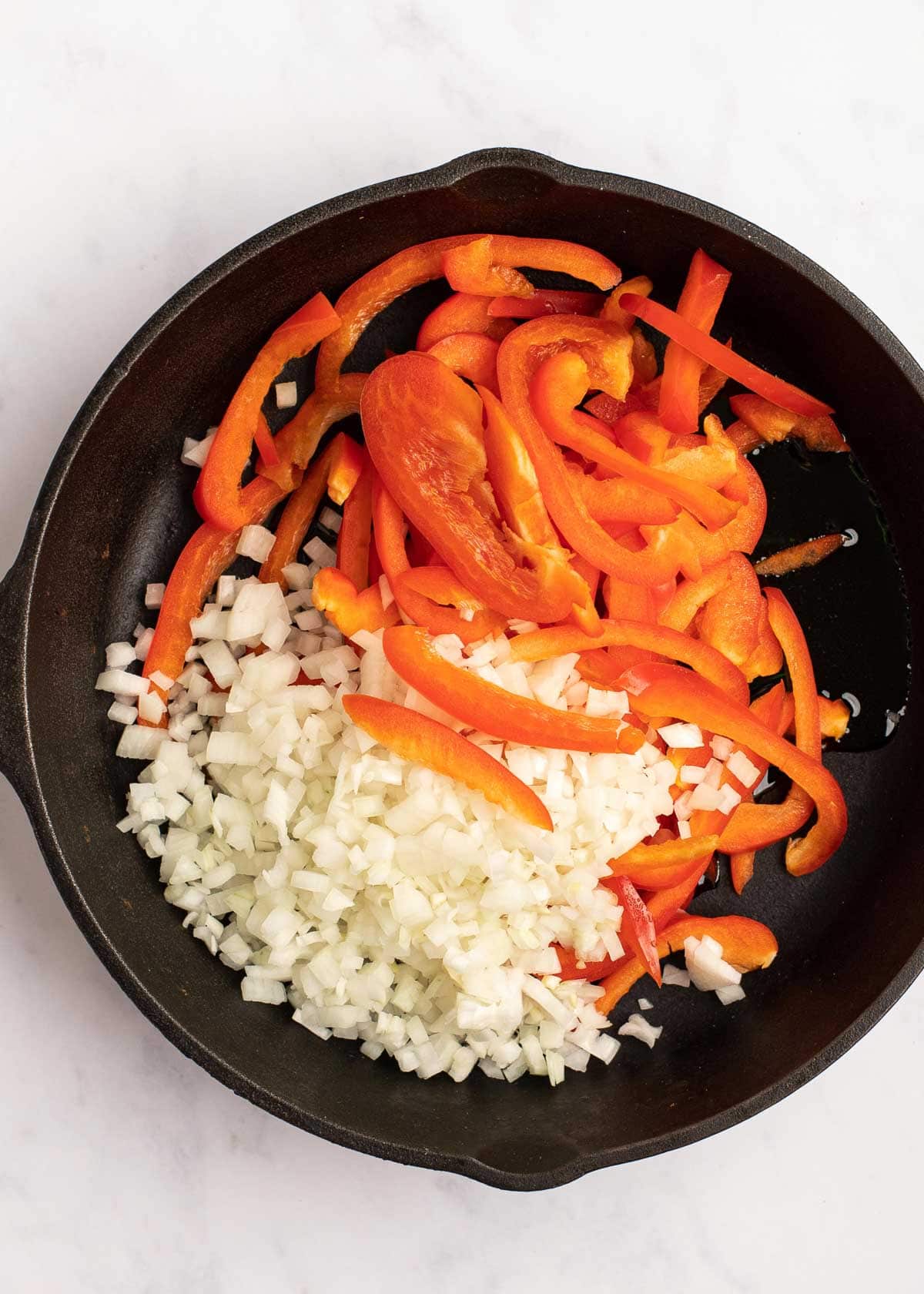 onions and peppers in skillet