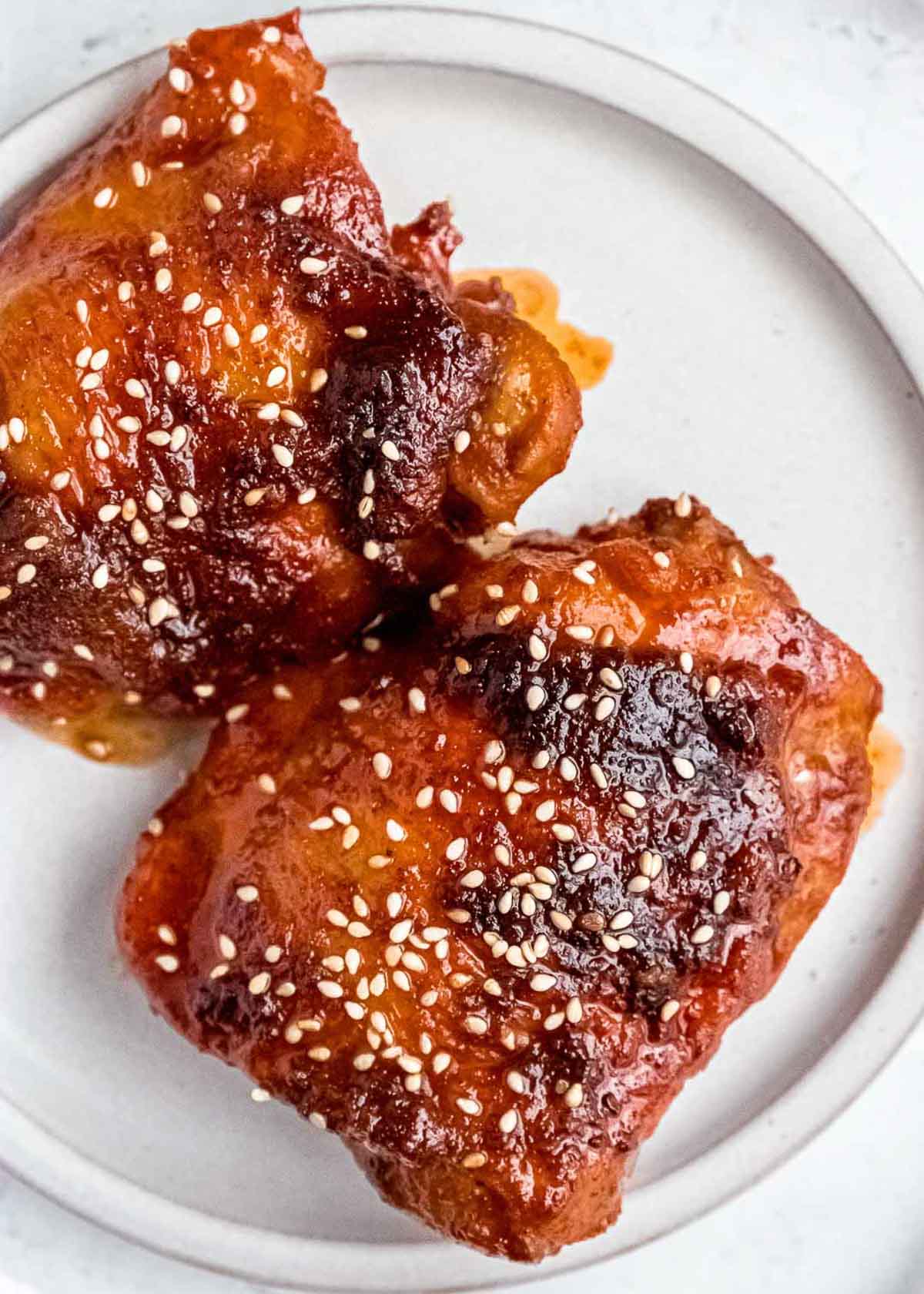 asian chicken thighs on plate with sesame seeds