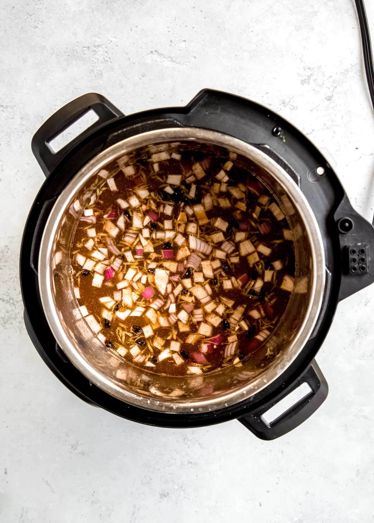 instant pot black bean ingredients being added to instant pot 