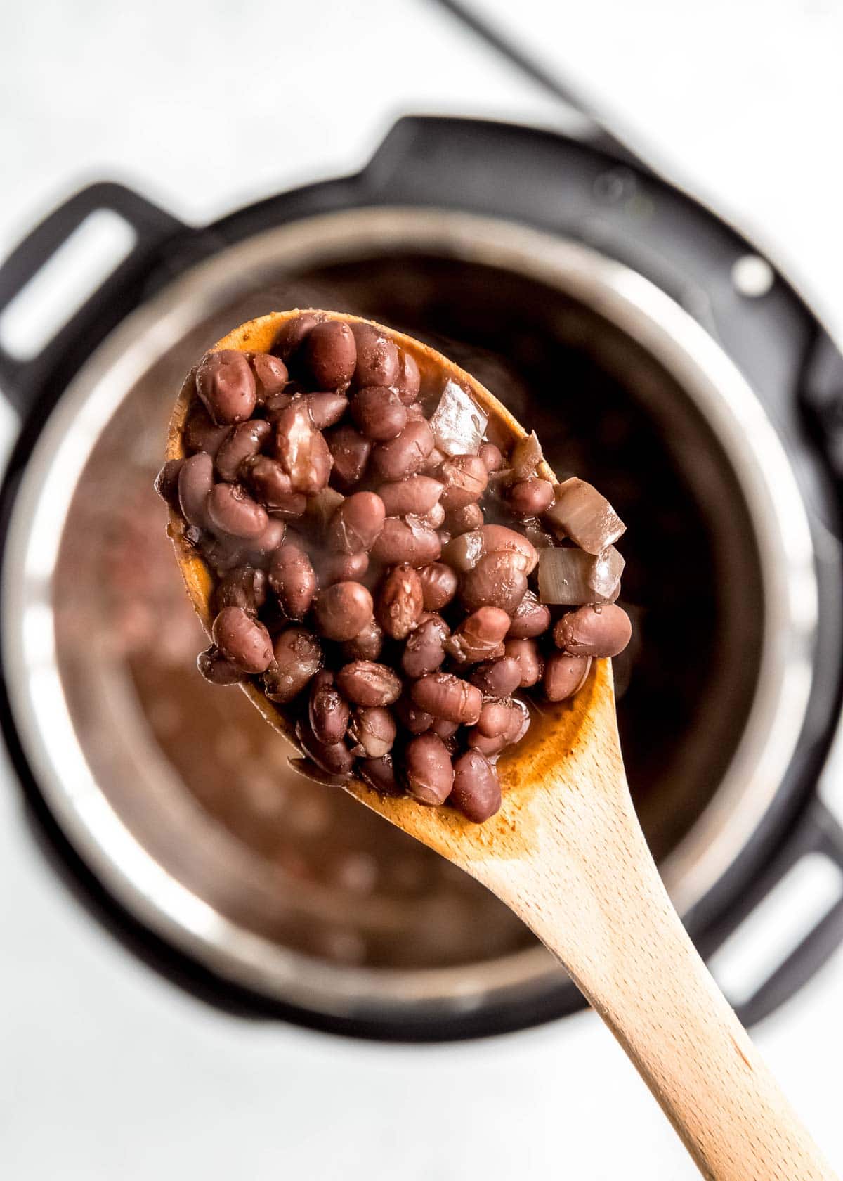 black beans being scooped from instant pot 