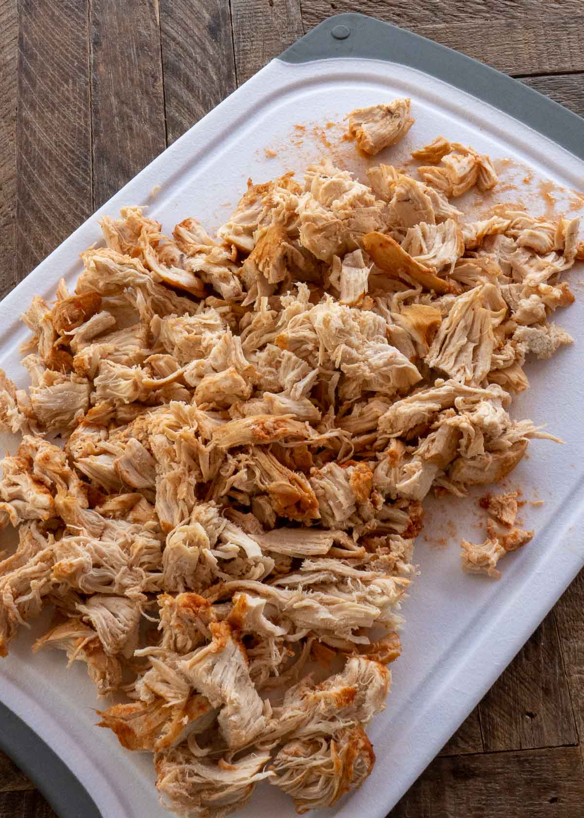 shredded chicken on white cutting board