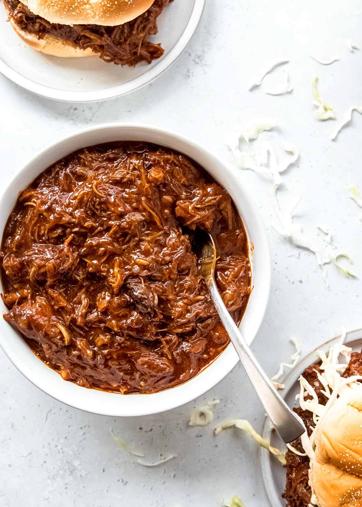 shredded pork in a white bowl on a white table