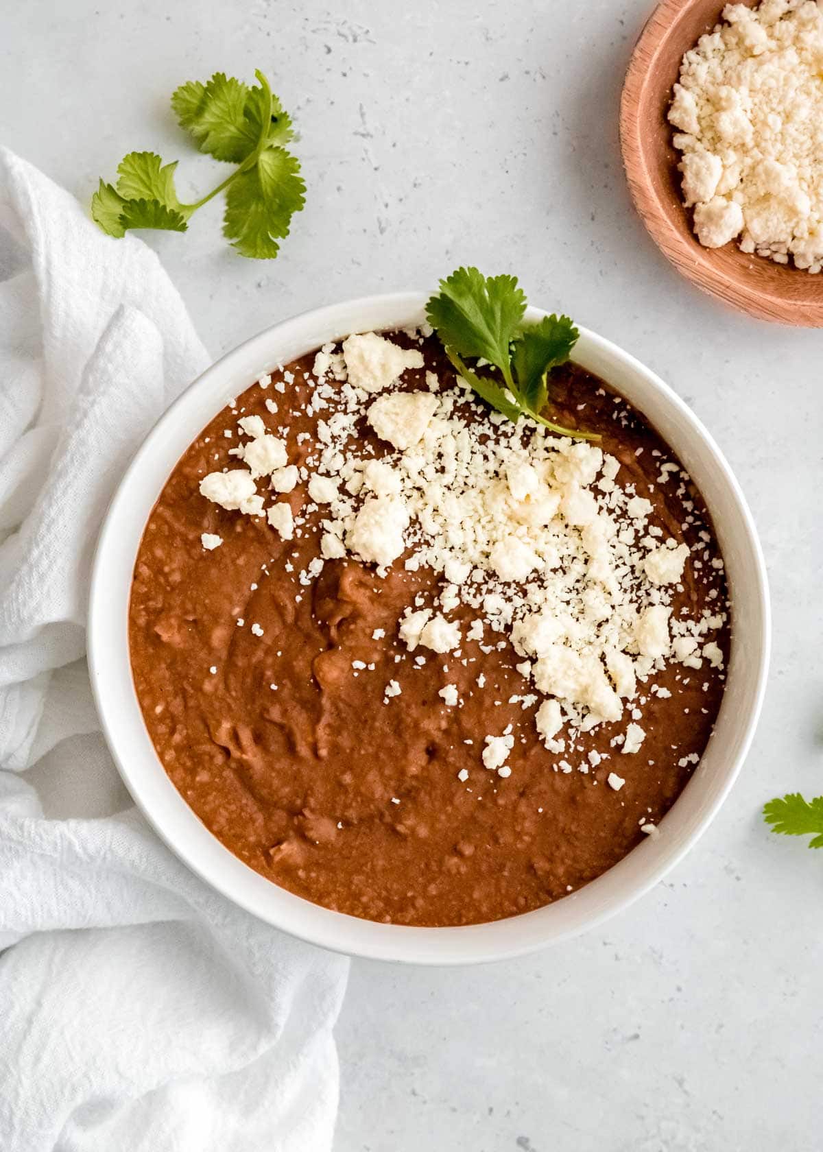 instant pot refried beans in a white bowl on a white table