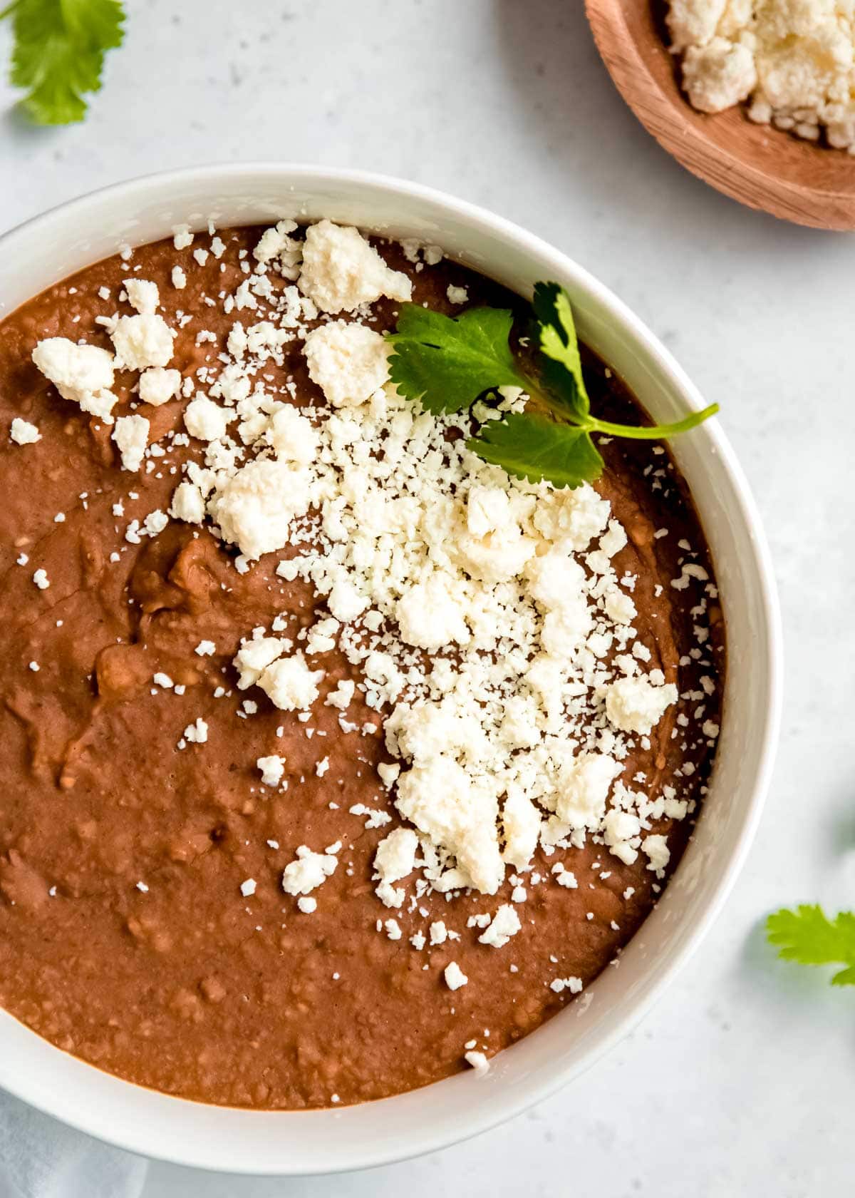 instant pot refried beans in a white bowl on a white table