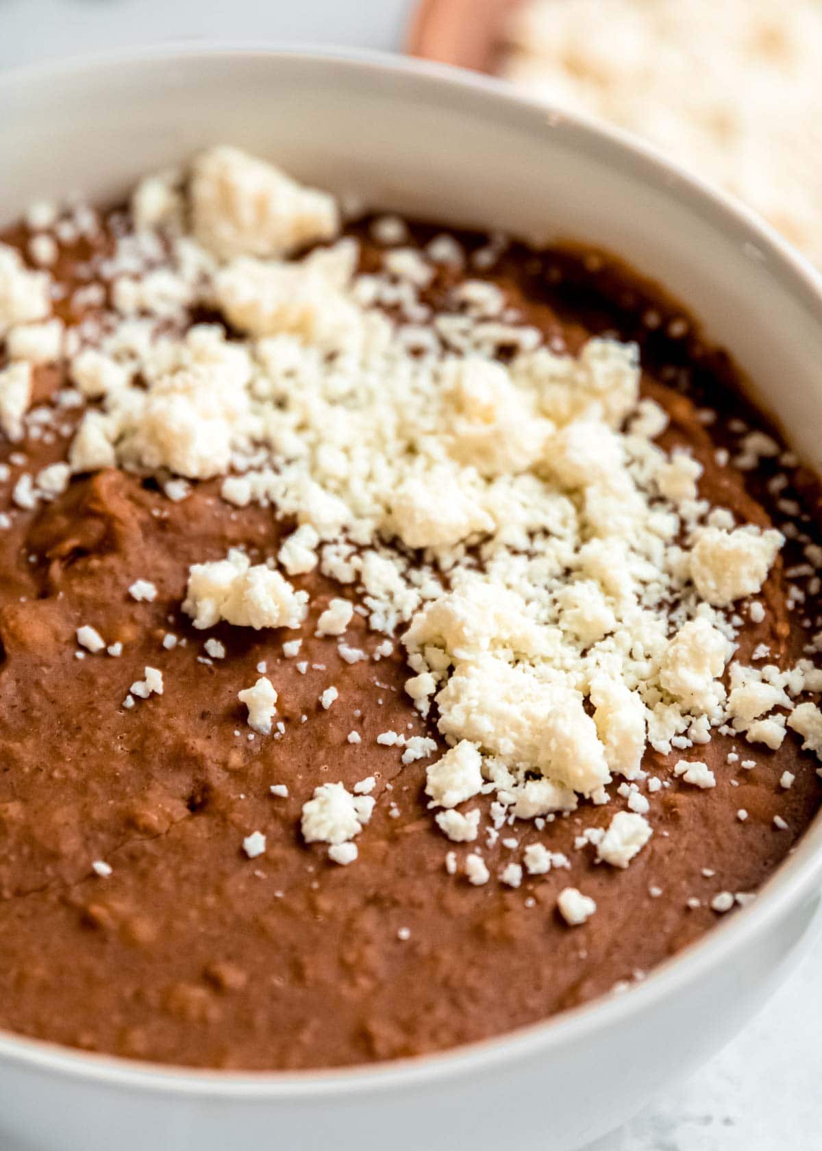 instant pot refried beans in a white bowl on a white table