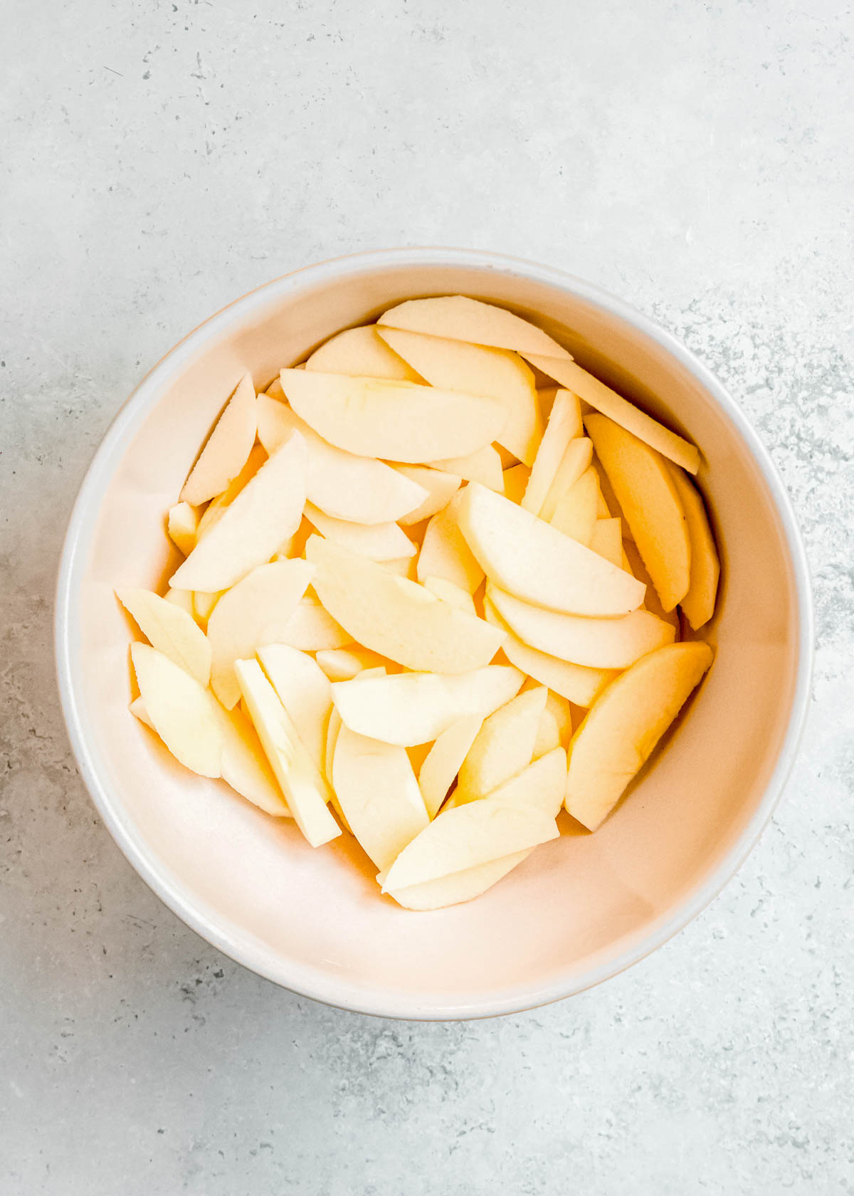 peeled and sliced apples in a bowl