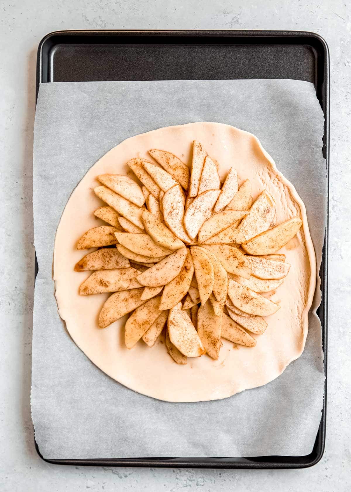 apples arranged in even layers in the middle of a pie crust