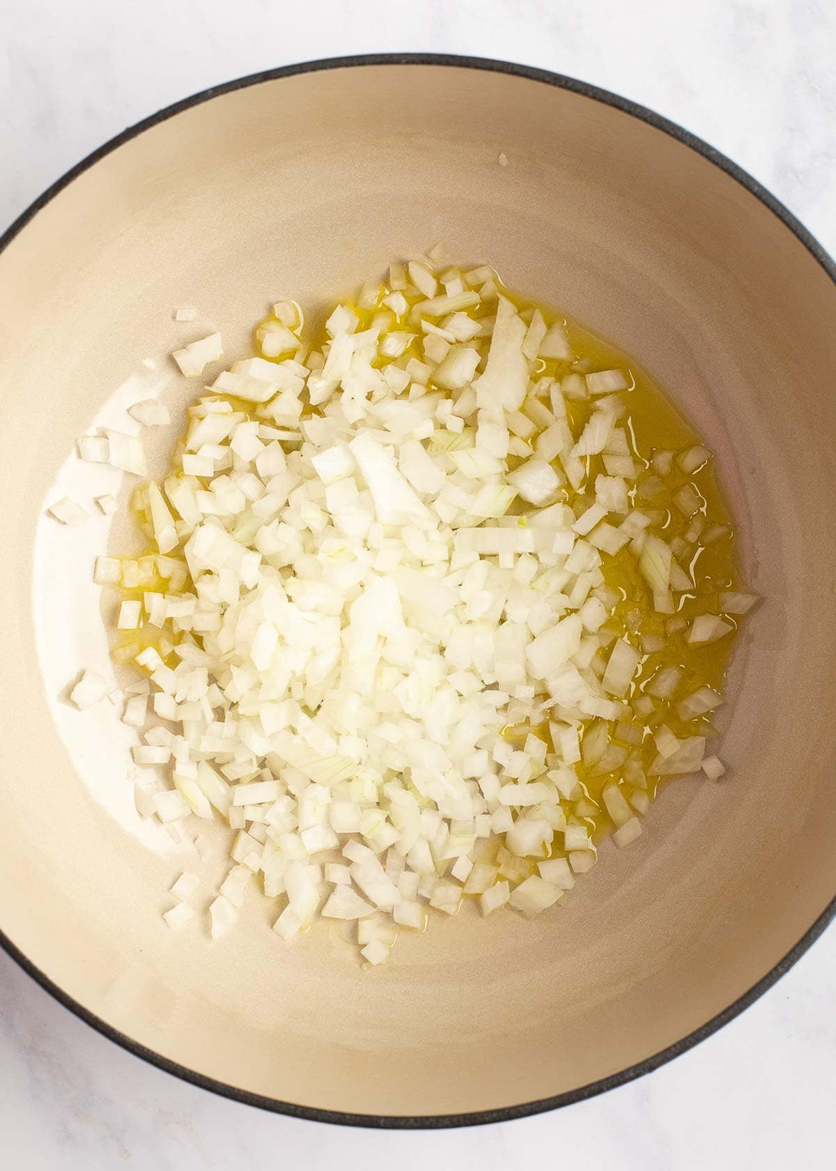 onions being cooked in a dutch oven