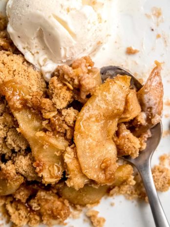 apple crumble on plate with ice cream and spoon