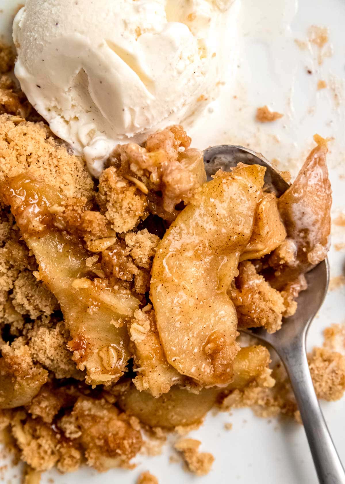 apple crumble on plate with ice cream and spoon