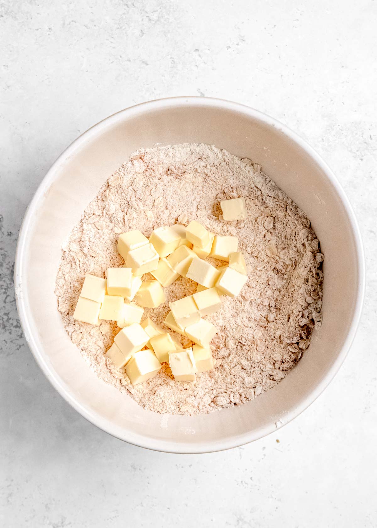 apple crumble ingredients with cubed butter in a bowl