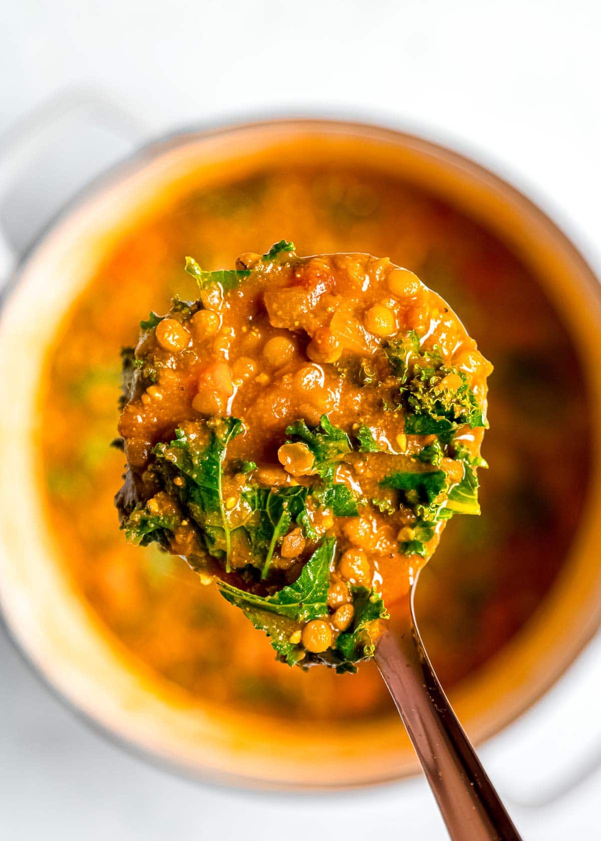 close up shot of spoon full of lentil soup