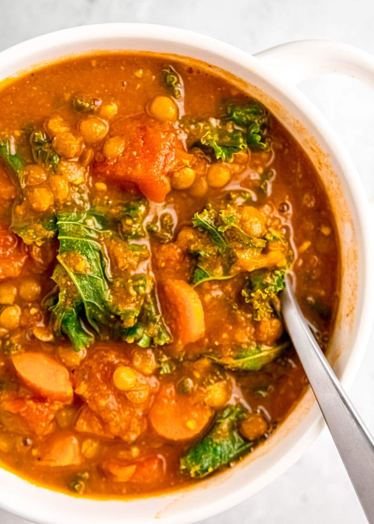 close up of lentil soup in white bowl