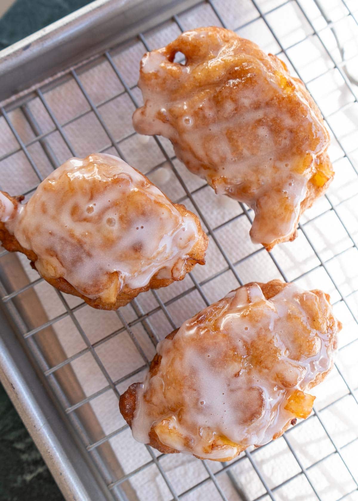 overhead shot of hot apple fritters with glaze