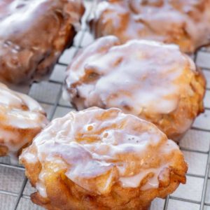 apple fritters on a cooling rack with glaze