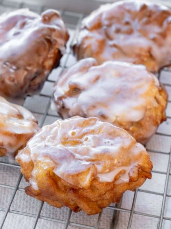 apple fritters on a cooling rack with glaze