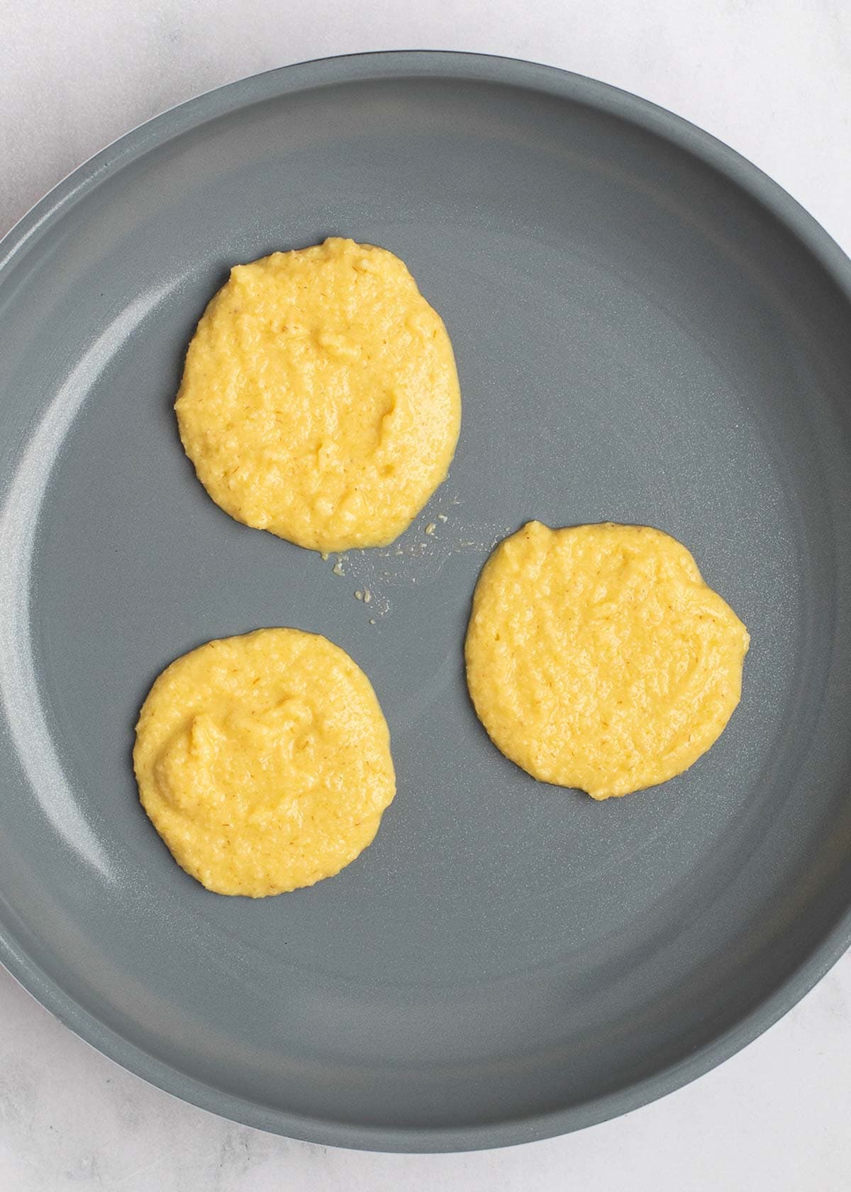 pancake batter in a gray skillet