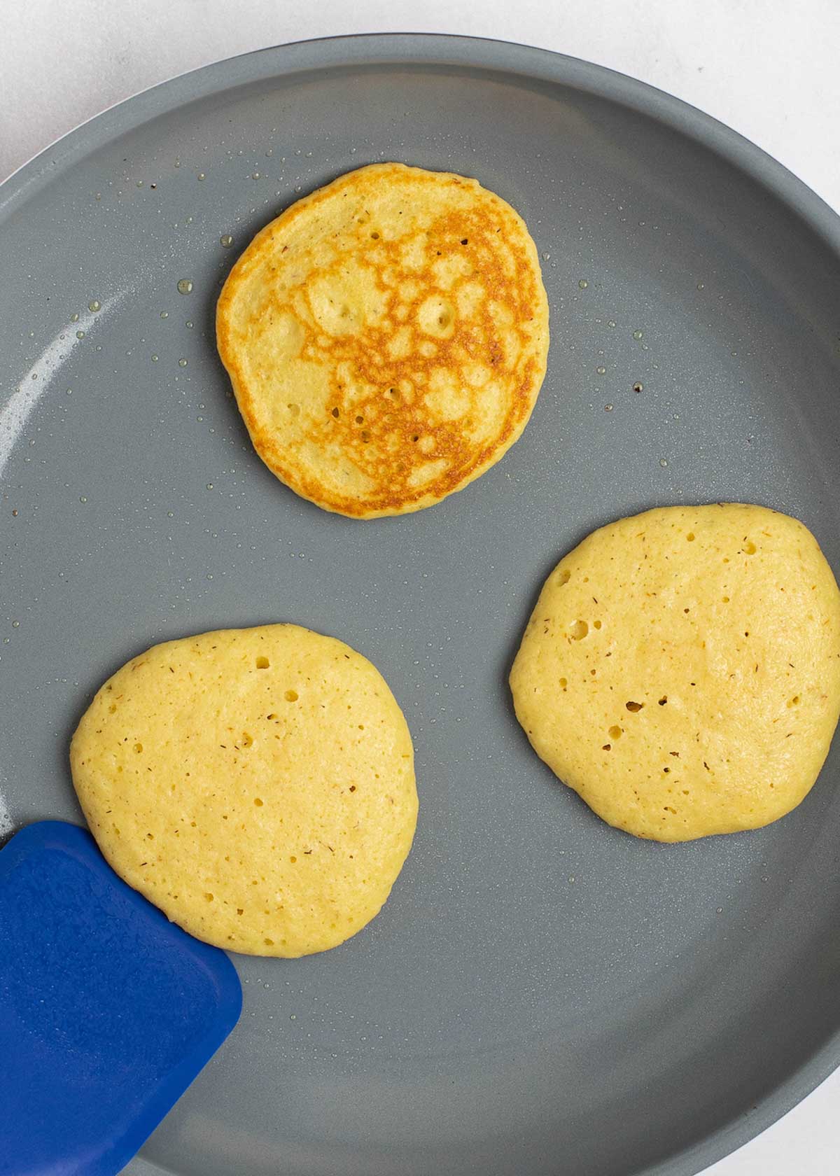 cooked pancakes in a gray skillet