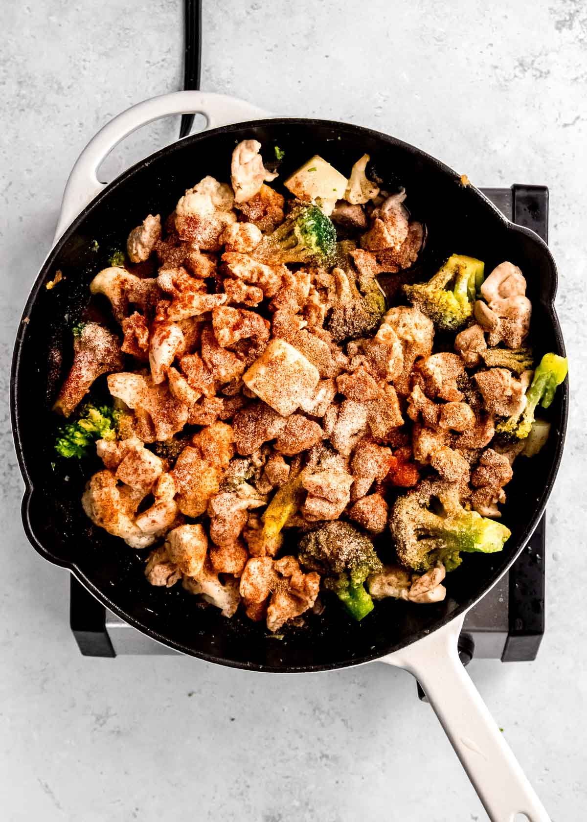 overhead image of chicken and veggies in cast iron skillet