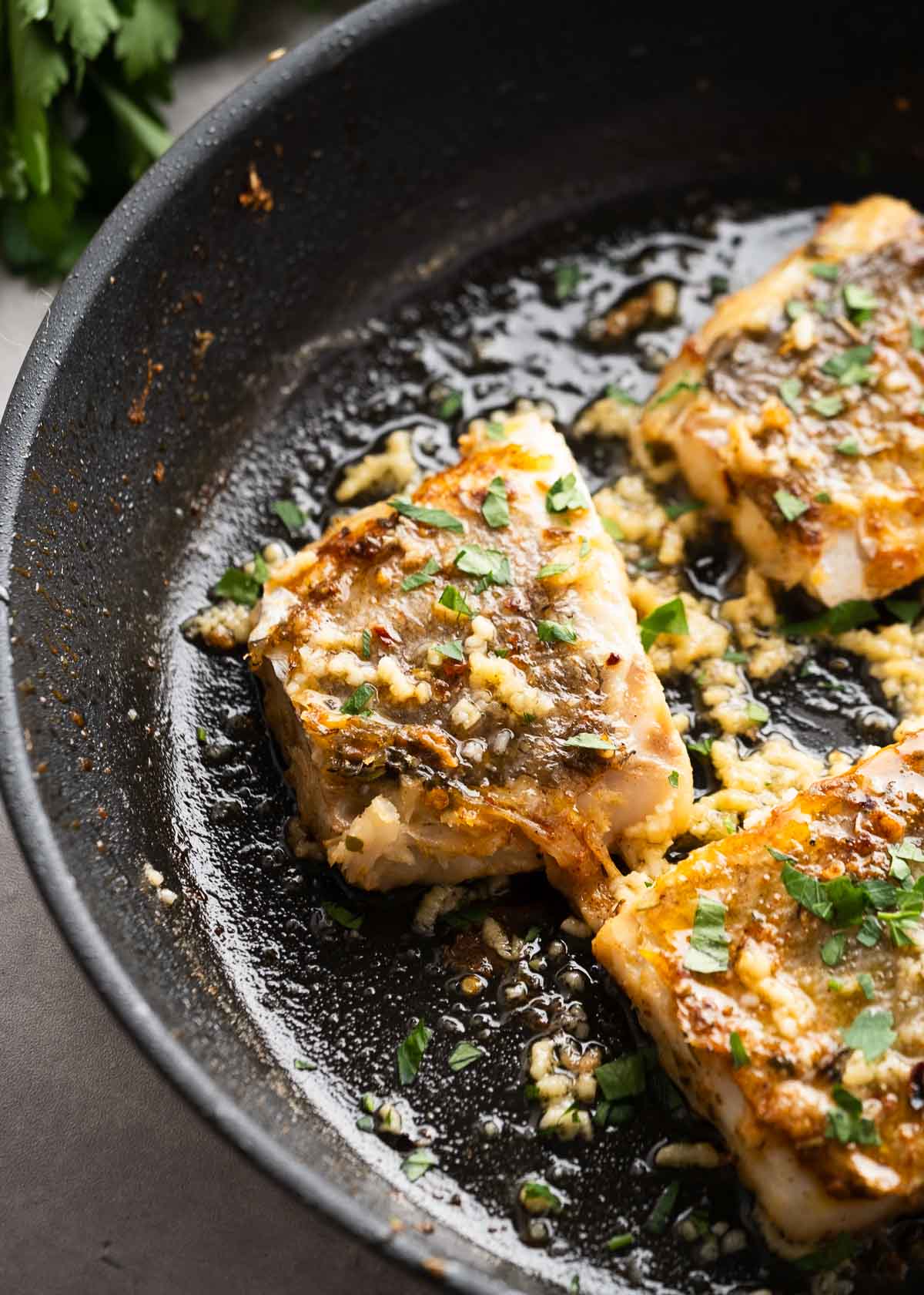 close up of cod being seared in a skillet