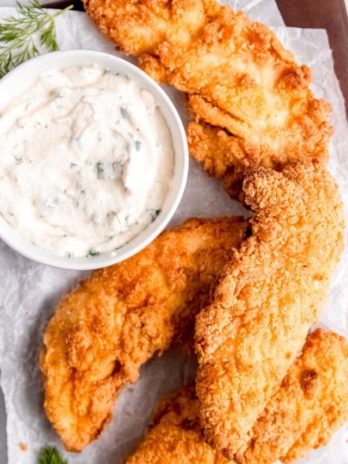 crispy buttermilk fried chicken tenders with a creamy homemade ranch dressing dip on the side