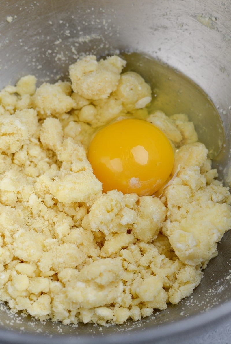 egg being added to gluten free pie crust