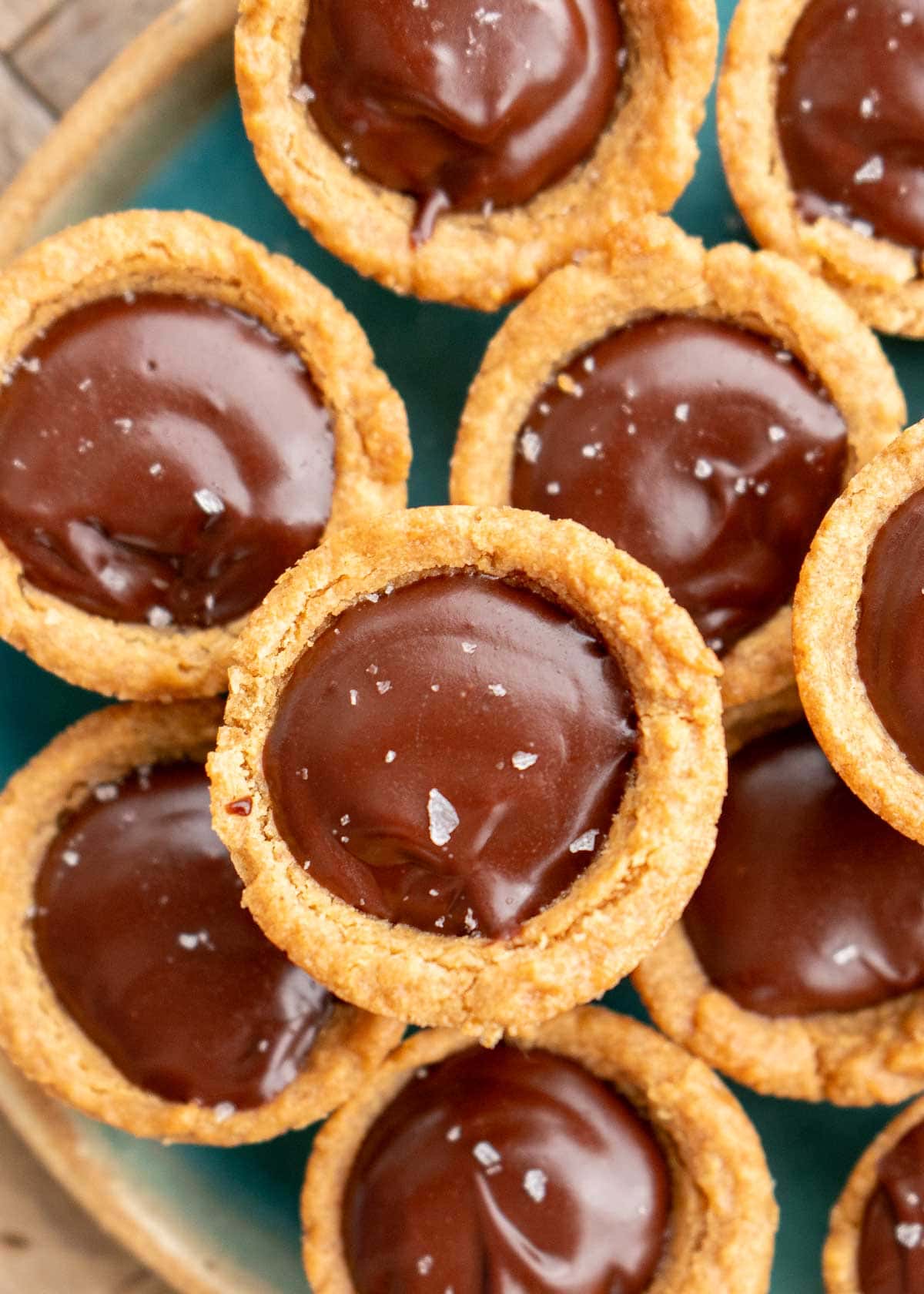 closeup view showing peanut butter cookie cups and low-carb chocolate ganache on a teal plate