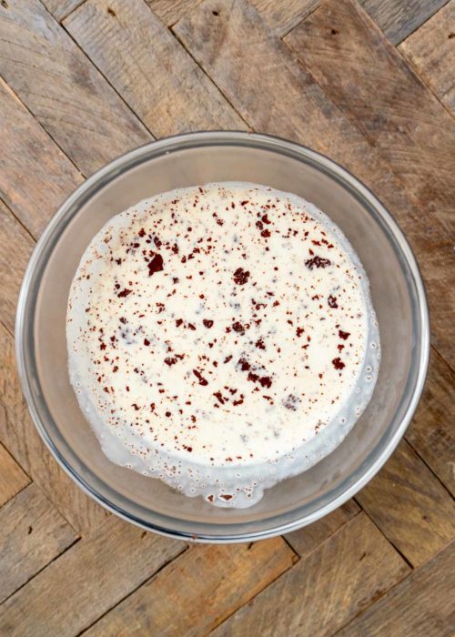 chocolate chips and hot heavy cream in a glass bowl