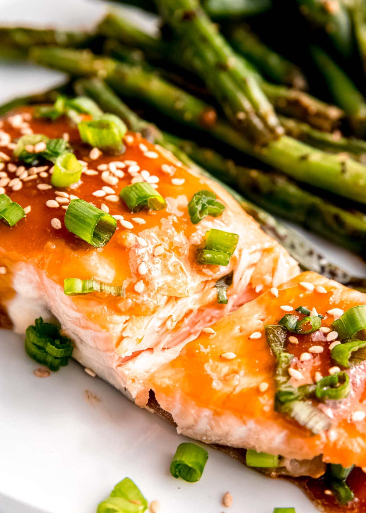 close up image of teriyaki salmon on white plate on white table