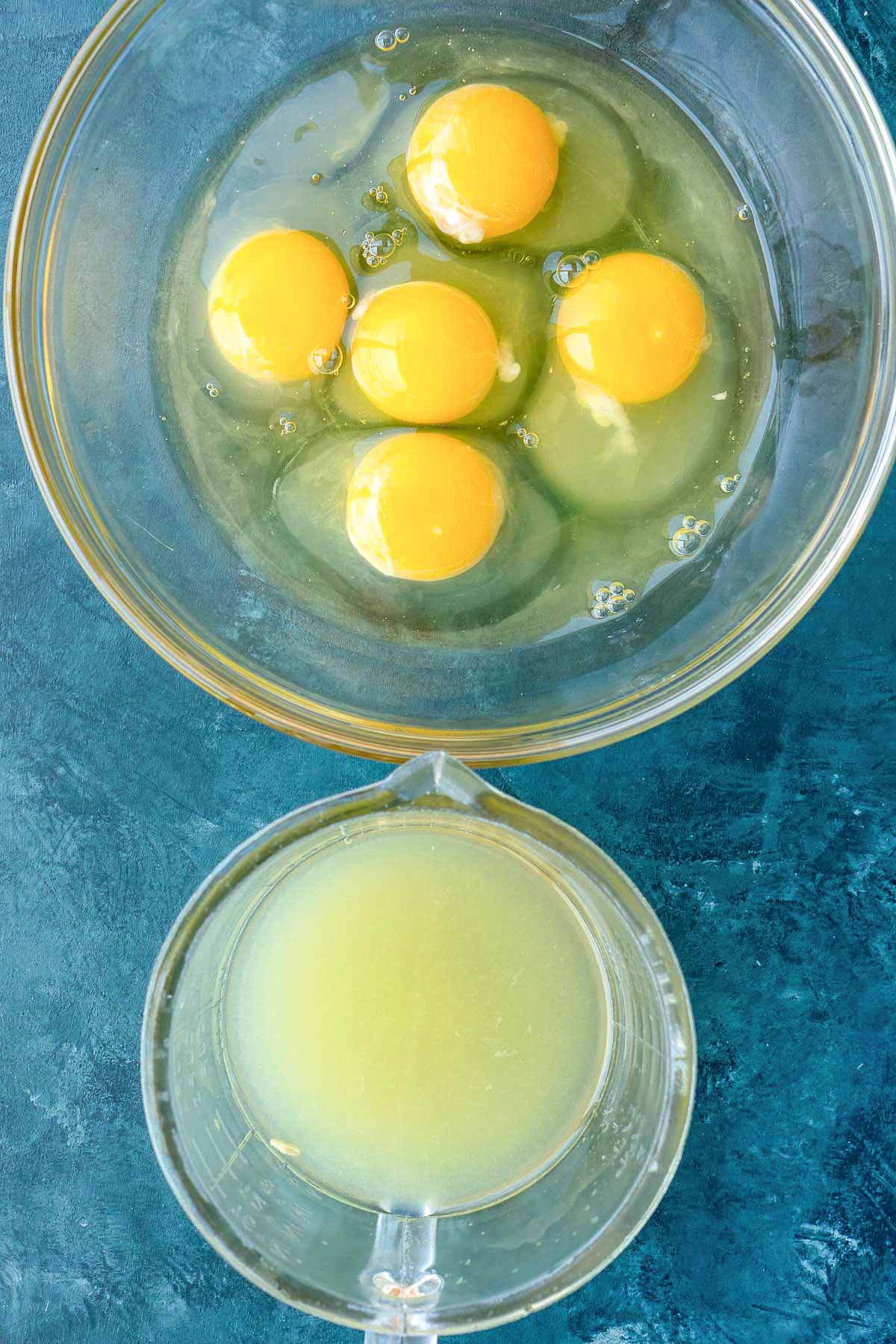 eggs and lemon juice in separate clear mixing bowls on table