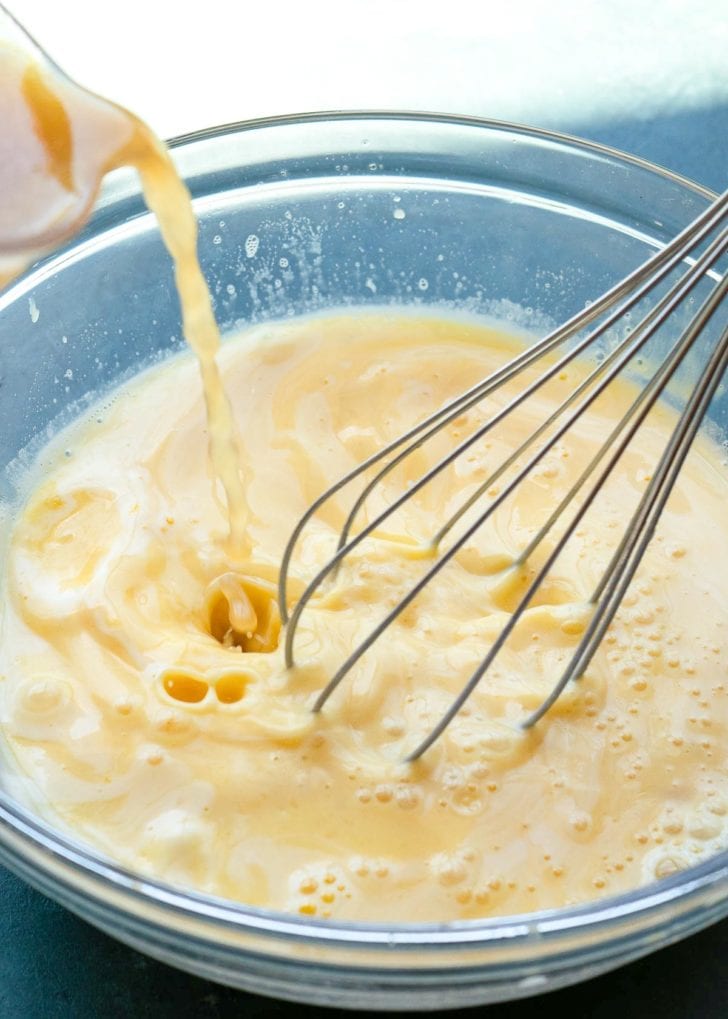 eggs and lemon juice being mixed in clear mixing bowl