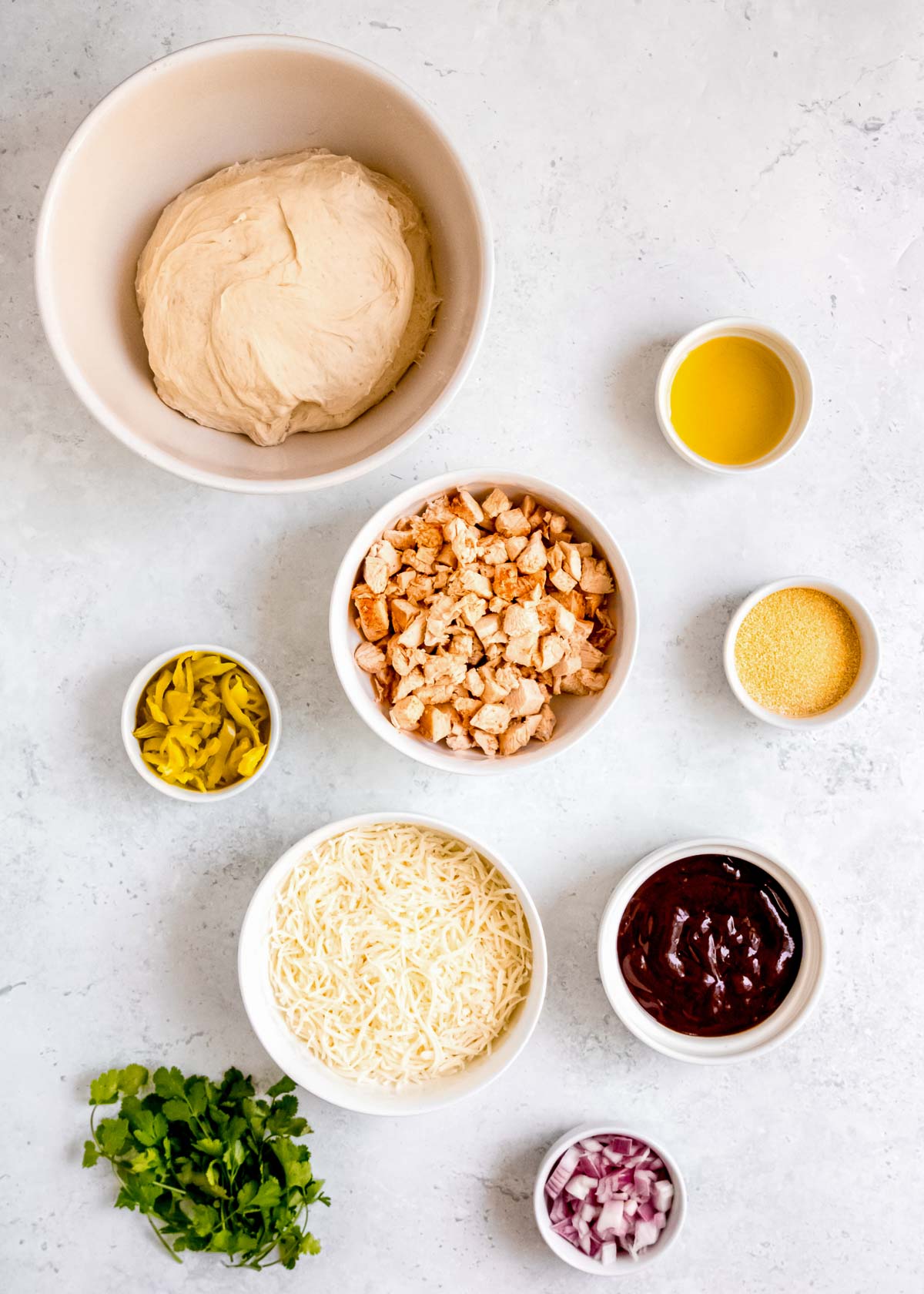 bbq chicken pizza ingredients on a white table 