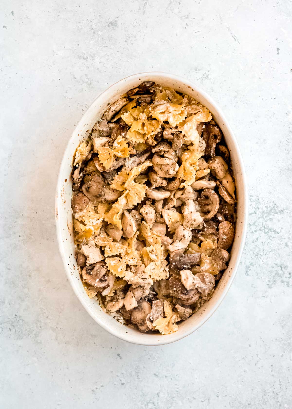 overhead image of baked chicken and mushroom pasta prior to adding spinach and cheese