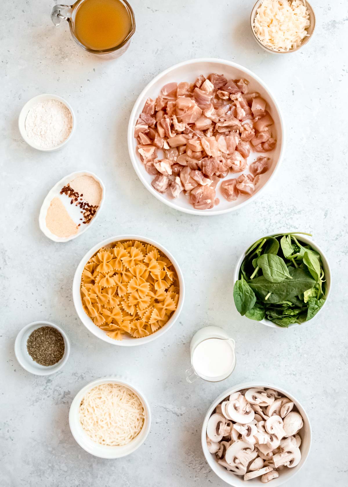 baked chicken and mushroom pasta ingredients on a white table