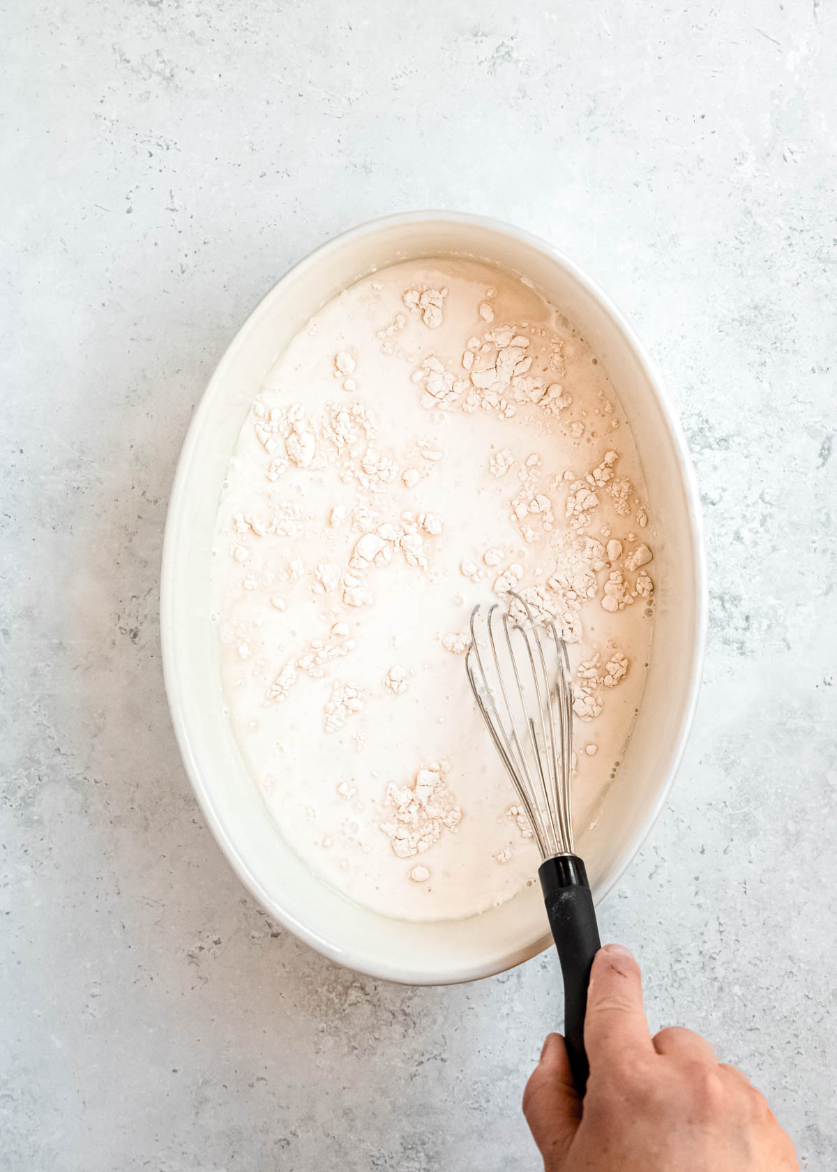 overhead image of flour being added to baking dish 