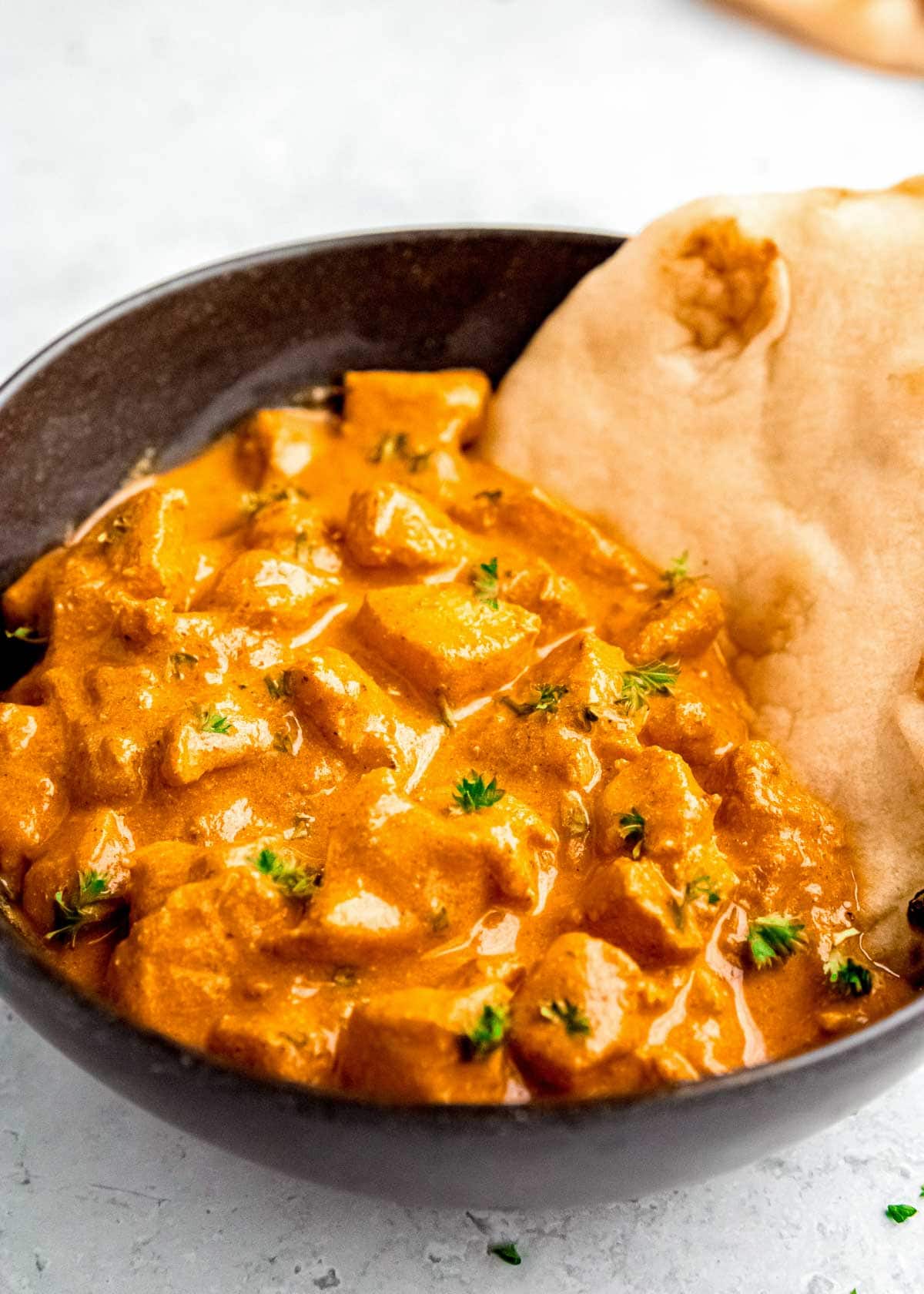 closeup shot showing the creamy Butter Chicken with naan made with this simplified Indian recipe