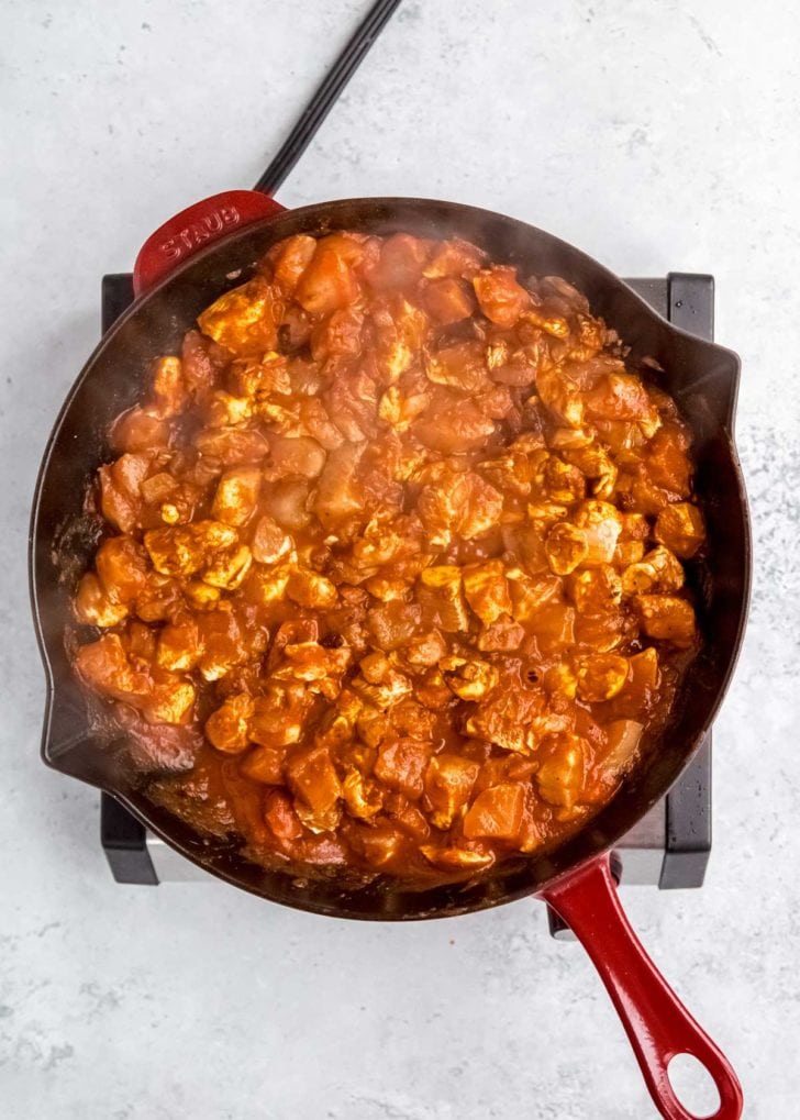 overhead image of butter chicken being cooked in skillet