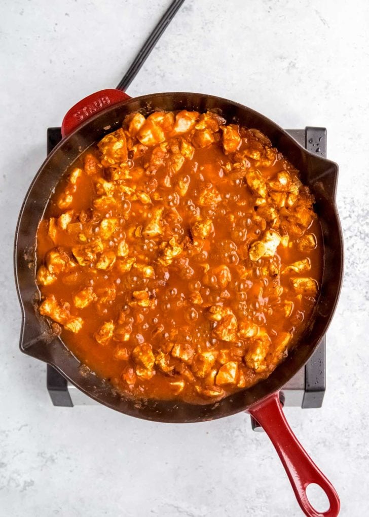 heavy cream being added to butter chicken