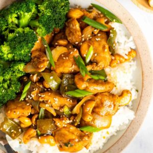 close up, overhead image of cashew chicken and rice on white plate