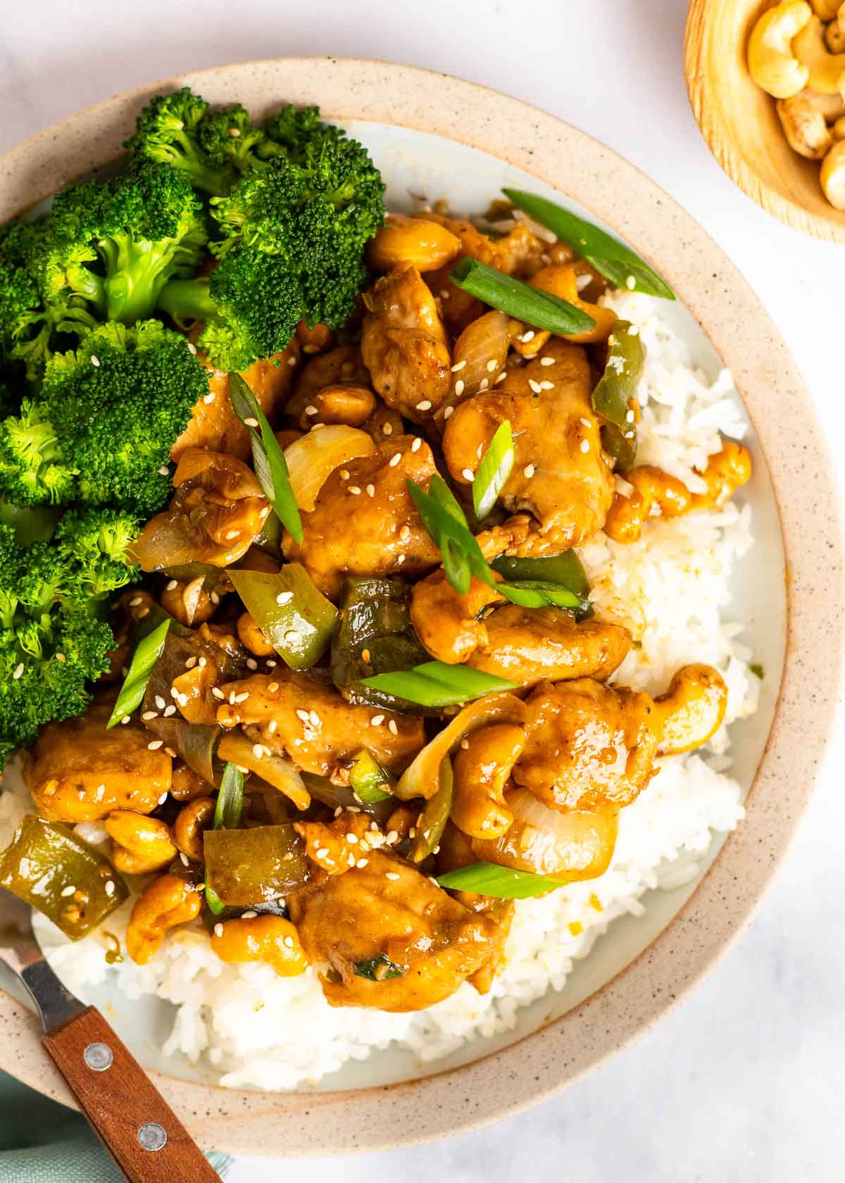 close up, overhead image of cashew chicken and rice on white plate 